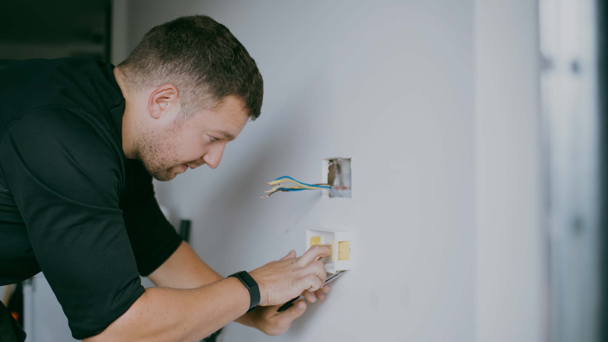 A heating engineer installinmg a smart home device