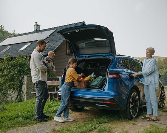 A family charging their electric vehicle from a home charging point